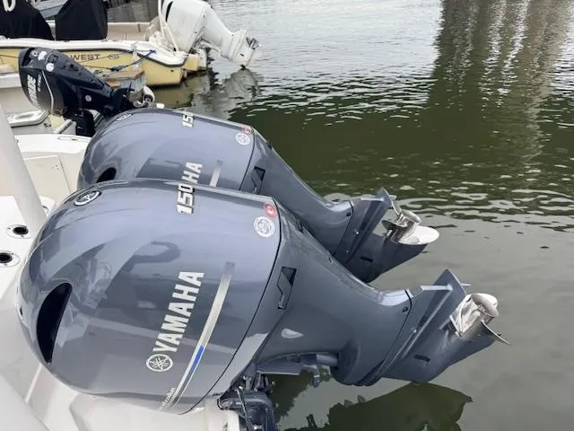 Slide: The Image of Twin Yamaha 150 outboard motors on a 2024 Pursuit S 268 boat, docked on calm water. - 20