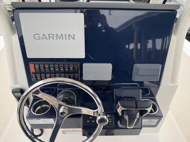 Slide: The Image of 2024 Pursuit S 268 boat dashboard with Garmin navigation system and steering wheel. - 22