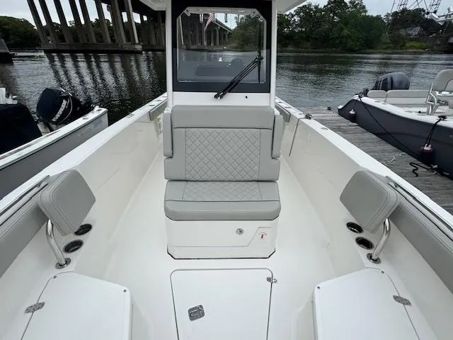 Slide: The Image of 2024 Pursuit S 268 boat interior with seating, docked by a river. - 25