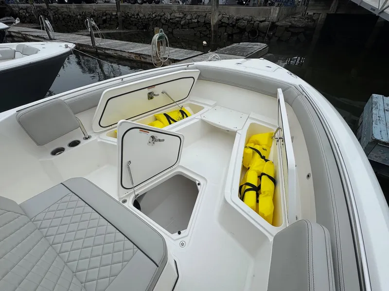 Slide: The Image of 2024 Pursuit S 268 boat with open storage compartments and visible life jackets. - 26