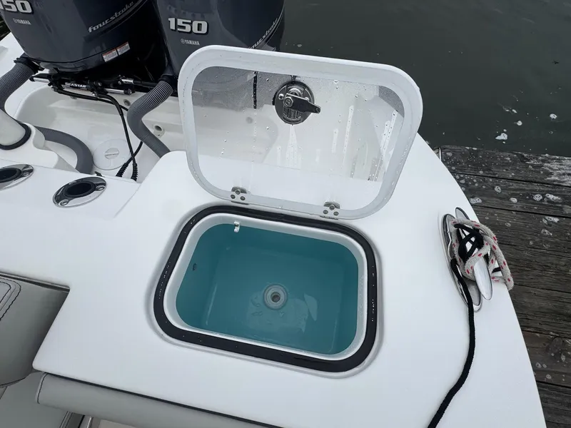 Slide: The Image of 2024 Pursuit S 268 boat with open livewell and dual outboard motors. - 35