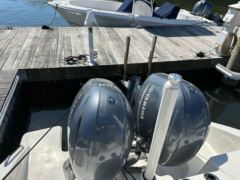 Slide: The Image of 2024 Pursuit S 268 boat with twin Yamaha engines docked at a wooden pier. - 4