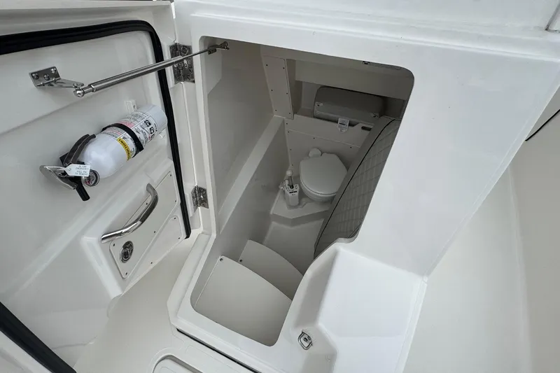 Slide: The Image of 2024 Pursuit S 268 boat interior with compact marine toilet and safety equipment. - 40