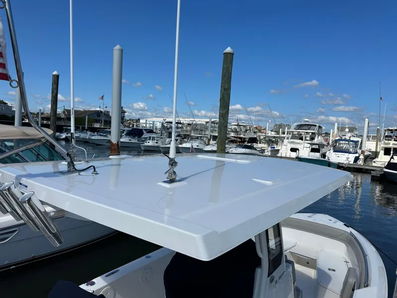 Slide: The Image of 2024 Pursuit S 268 boat docked at a marina under a clear blue sky. - 6