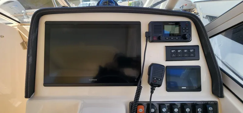 Slide: The Image of 2023 Grady-White Freedom 235 dashboard with navigation and communication equipment. - 14