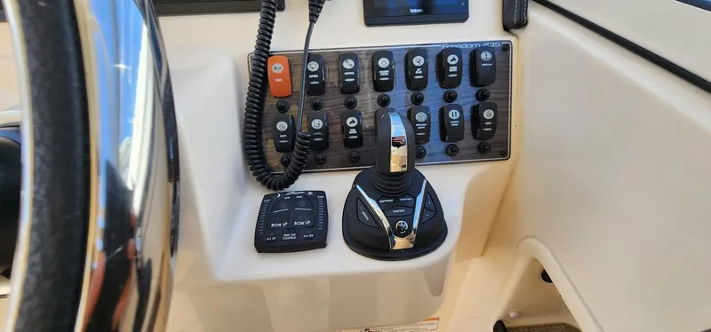 Slide: The Image of Control panel of 2023 Grady-White Freedom 235 boat with switches and joystick. - 15