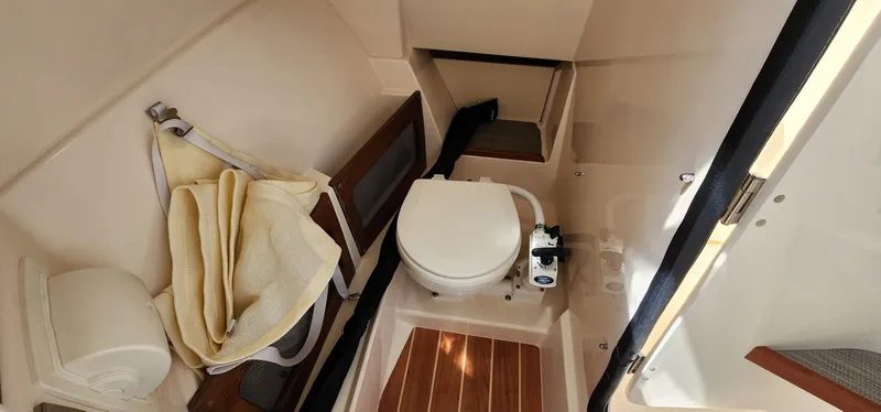 Slide: The Image of 2023 Grady-White Freedom 235 boat interior with toilet and wooden flooring. - 21
