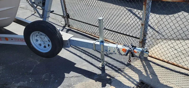 Slide: The Image of Trailer hitch of 2023 Grady-White Freedom 235 boat, parked near a chain-link fence. - 31