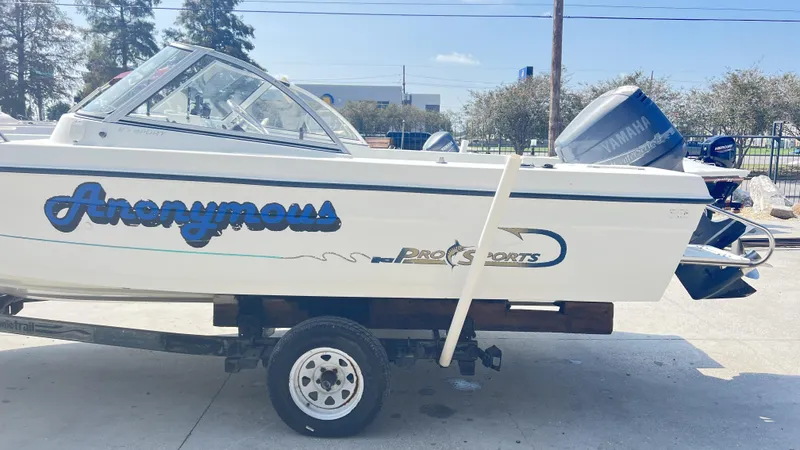 Slide: The Image of 1998 Pro Sports Walk Through boat interior with steering wheel and dashboard, docked outdoors. - 5