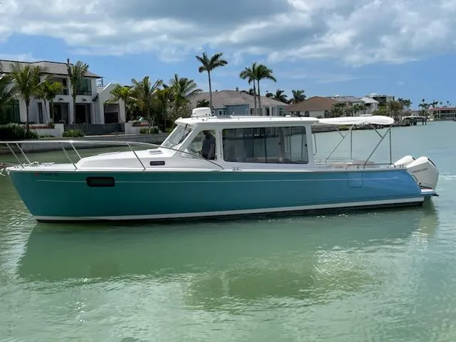 The Image of 2023 MJM 35z boat on calm water with palm trees and houses in the background. - 0