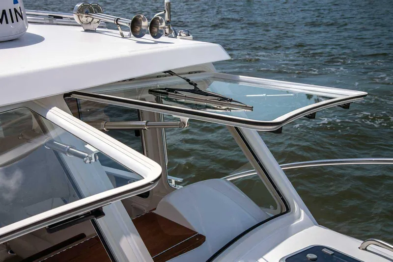 Slide: The Image of 2023 MJM 35z boat with open windows, showcasing sleek design and water in the background. - 11