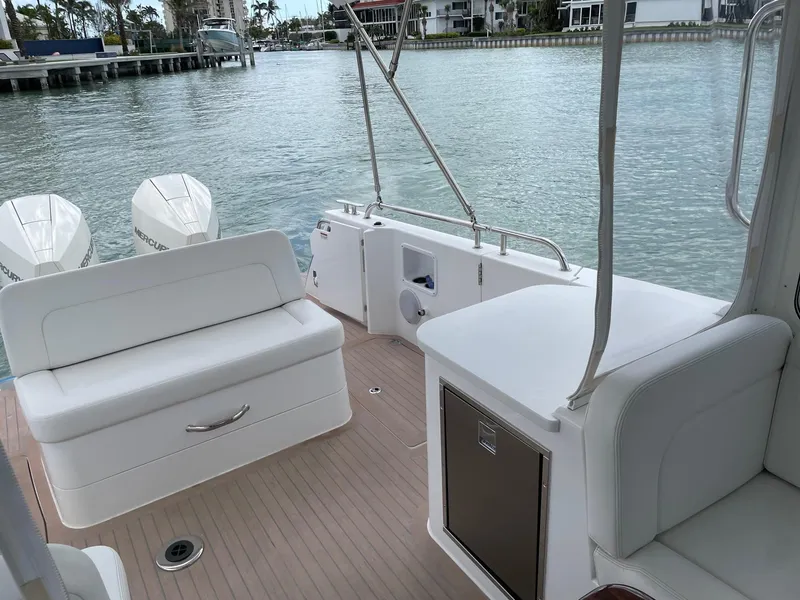 Slide: The Image of 2023 MJM 35z boat interior with white seating and scenic waterfront view. - 15
