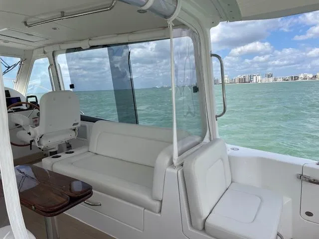 Slide: The Image of 2023 MJM 35z yacht interior with seating, ocean view, and city skyline in the background. - 16