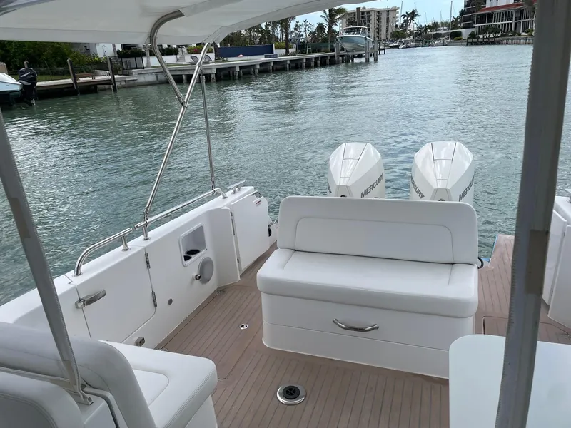 Slide: The Image of 2023 MJM 35z boat with twin engines, docked on a calm waterfront. - 21