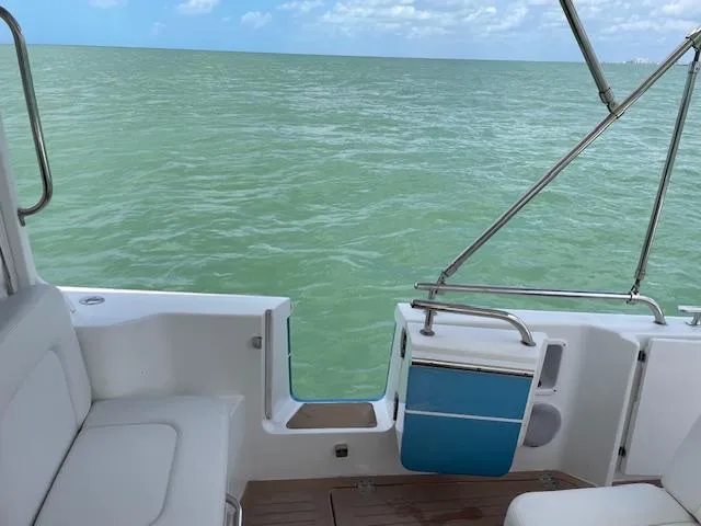 Slide: The Image of 2023 MJM 35z boat interior with ocean view, featuring white seating and blue accents. - 24