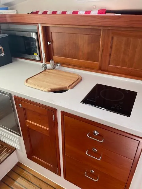 Slide: The Image of 2023 MJM 35z yacht kitchen with wooden cabinetry, sink, and stovetop. - 30