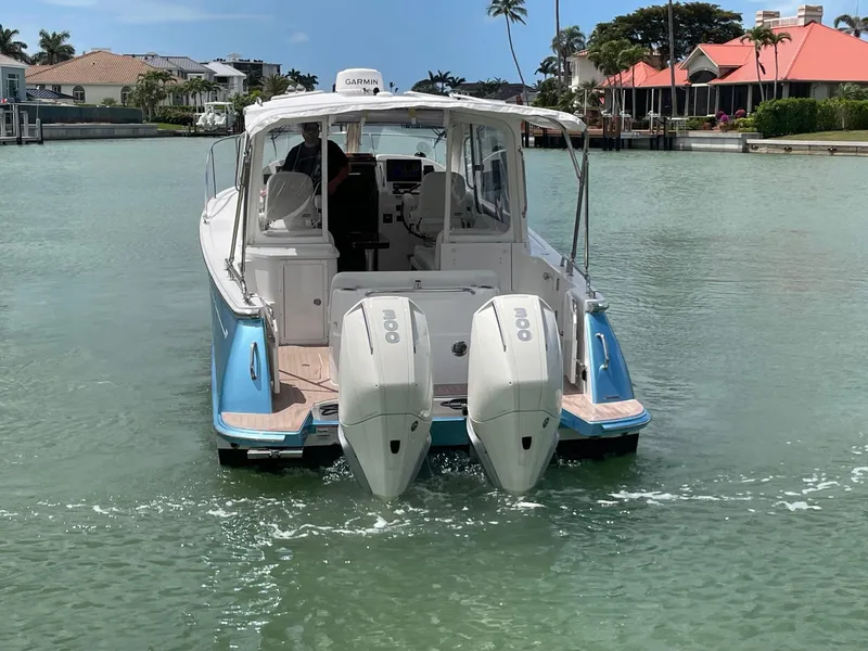 Slide: The Image of 2023 MJM 35z boat with dual engines cruising in a scenic canal. - 6