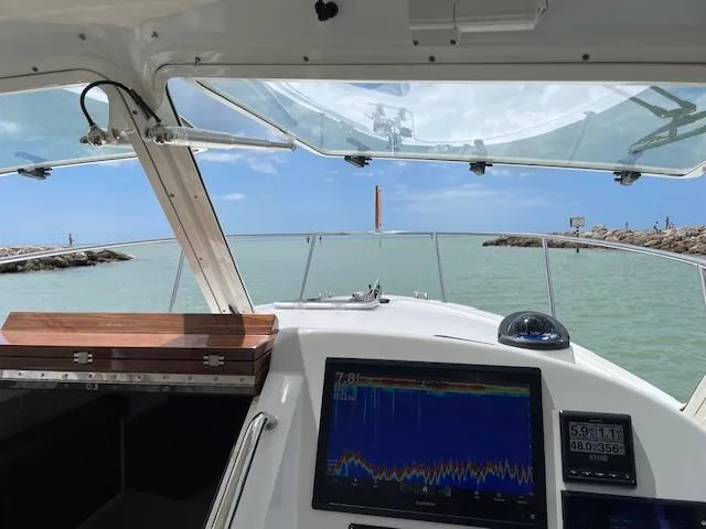 Slide: The Image of 2023 MJM 35z boat cockpit with navigation screens, cruising through calm waters. - 9