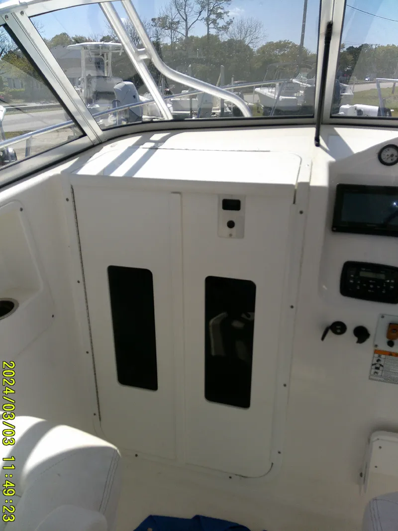 Slide: The Image of 2013 Sea Fox 236 Voyager boat interior with control panel and seating area. - 11