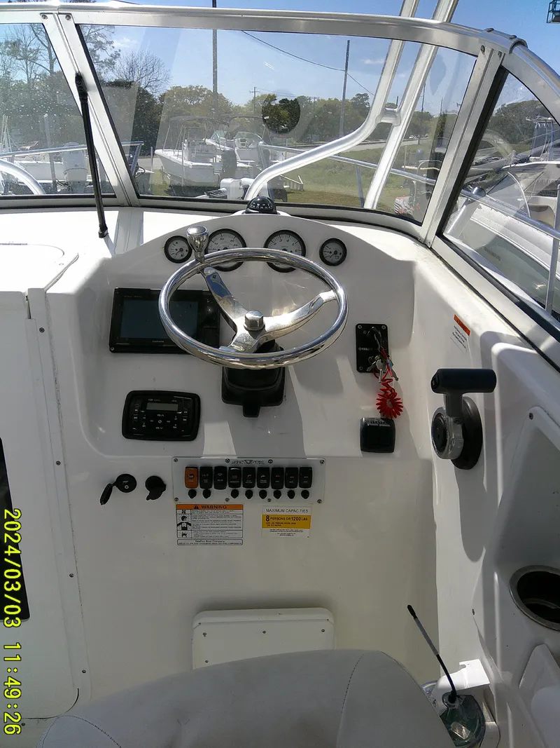 Slide: The Image of 2013 Sea Fox 236 Voyager boat dashboard with steering wheel and control panel. - 12