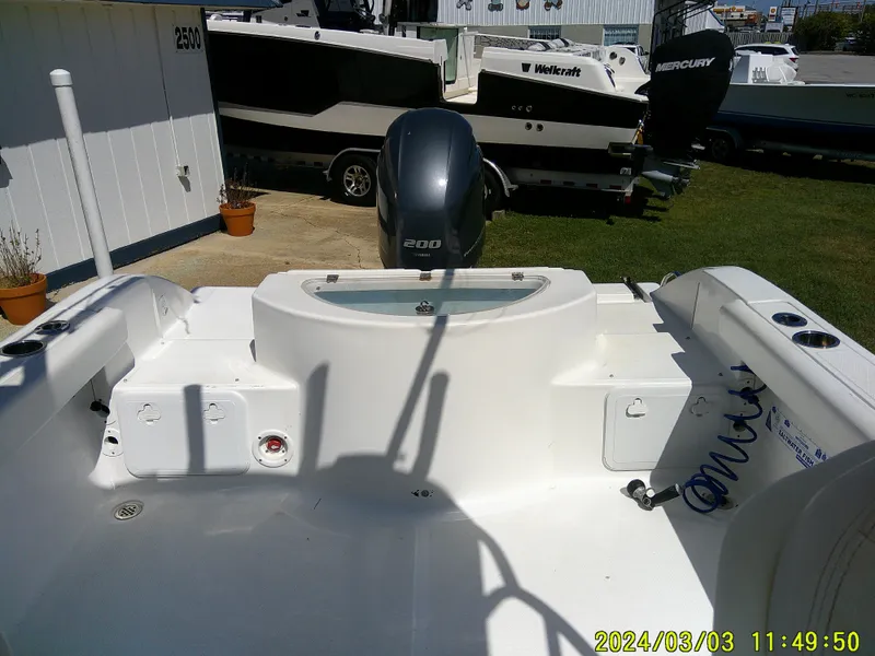 Slide: The Image of 2013 Sea Fox 236 Voyager boat interior with motor, docked outdoors. - 13