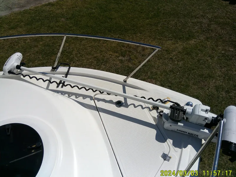 Slide: The Image of 2013 Sea Fox 236 Voyager boat deck with mounted trolling motor, grassy background. - 22