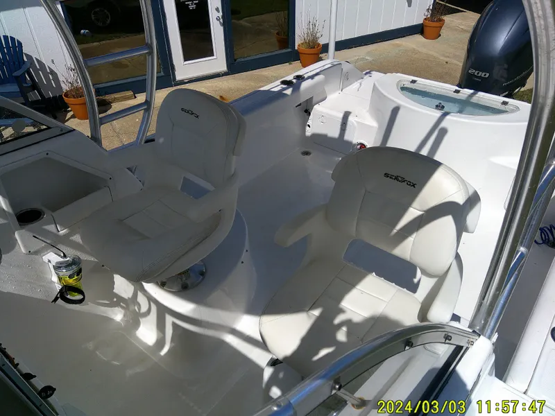Slide: The Image of 2013 Sea Fox 236 Voyager boat interior with white seating and helm area. - 24