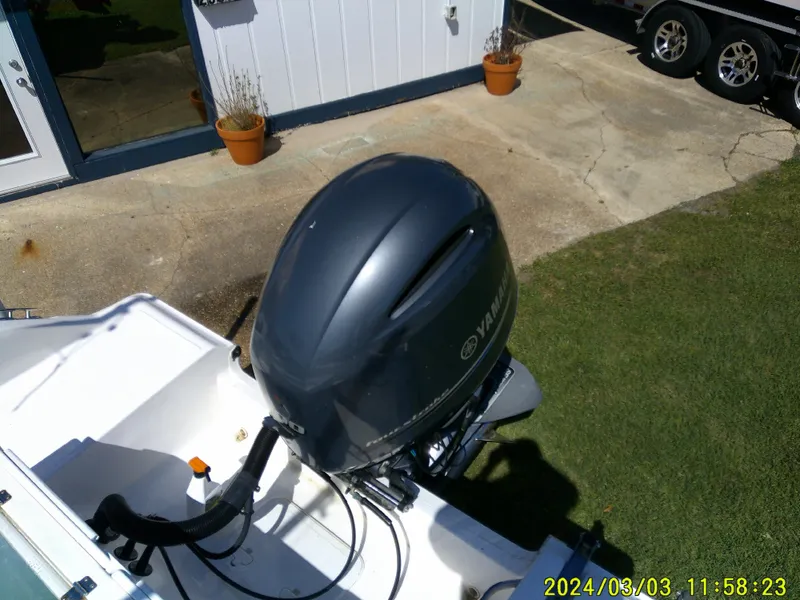 Slide: The Image of 2013 Sea Fox 236 Voyager with Yamaha outboard motor, parked on grass near a building. - 30