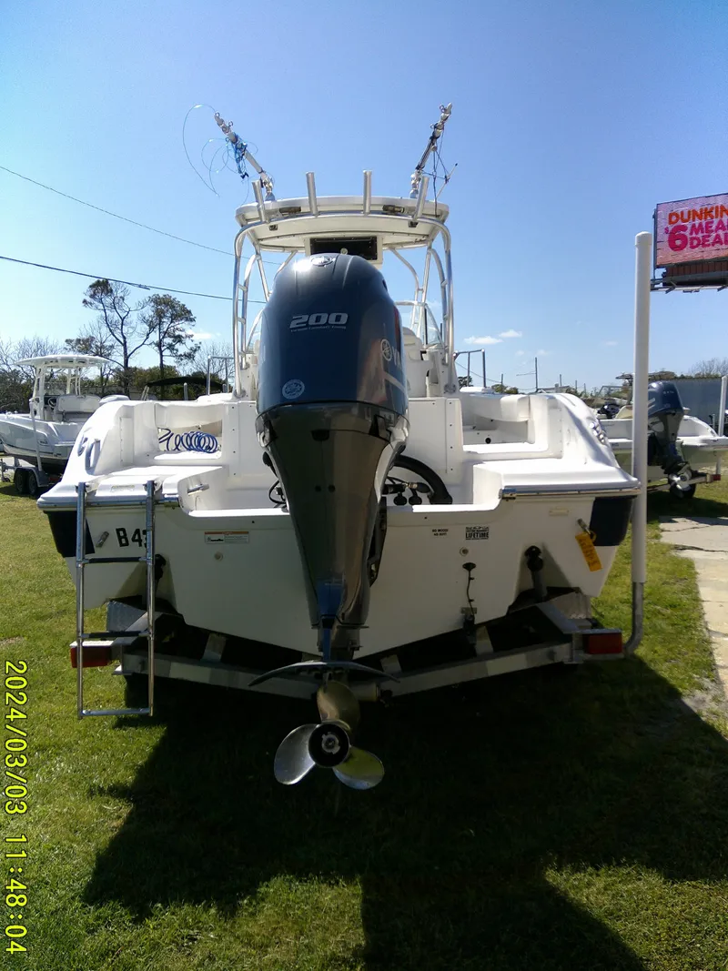 Slide: The Image of 2013 Sea Fox 236 Voyager boat with outboard motor, parked on grass. - 8