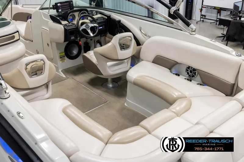 Slide: The Image of 2014 Crownline 255 SS boat interior with beige seating and modern dashboard. - 10