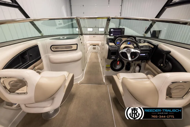 Slide: The Image of Interior of a 2014 Crownline 255 SS boat, featuring beige seating and modern controls. - 13