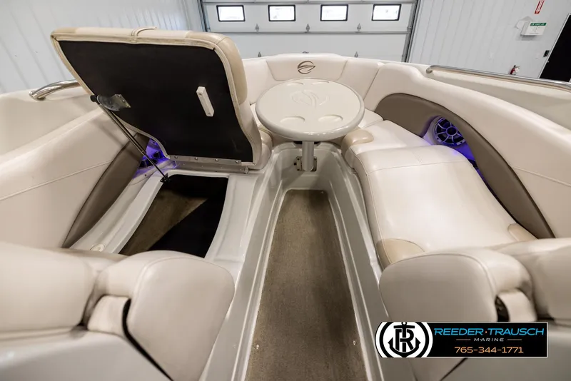 Slide: The Image of 2014 Crownline 255 SS boat interior with seating and table in a showroom. - 15