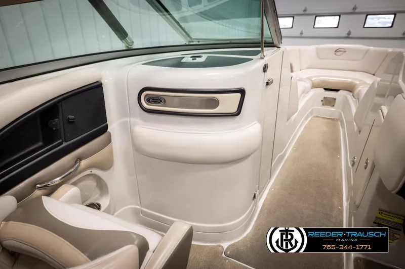 Slide: The Image of 2014 Crownline 255 SS boat interior with beige seating and carpeted flooring. - 21