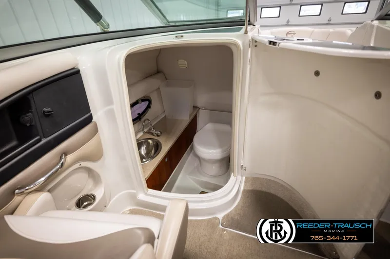 Slide: The Image of Interior of 2014 Crownline 255 SS boat featuring a compact bathroom with sink and toilet. - 22
