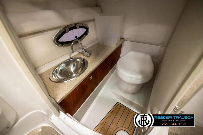 Slide: The Image of 2014 Crownline 255 SS boat bathroom with sink, toilet, and wooden accents. - 23