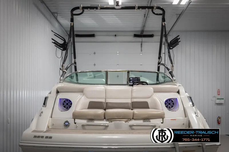 Slide: The Image of 2014 Crownline 255 SS boat interior with beige seating and speakers in a garage. - 6