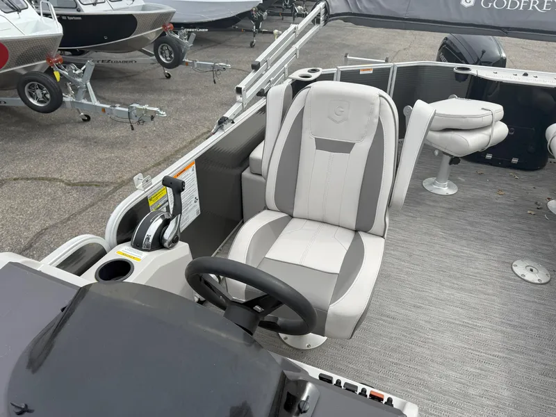 Slide: The Image of 2022 Godfrey Sweetwater 1886 FX boat interior with steering wheel and seating. - 11