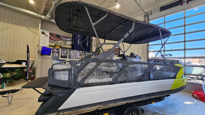 Slide: The Image of 2023 Sea-Doo Switch Cruise 21 pontoon boat displayed indoors with canopy. - 3