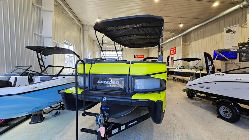 Slide: The Image of 2023 Sea-Doo Switch Cruise 21 in showroom, vibrant yellow, with canopy and trailer. - 5