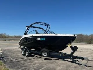 Slide: The Image of 2025 Yamaha Boats AR220 on trailer under clear blue sky. - 1