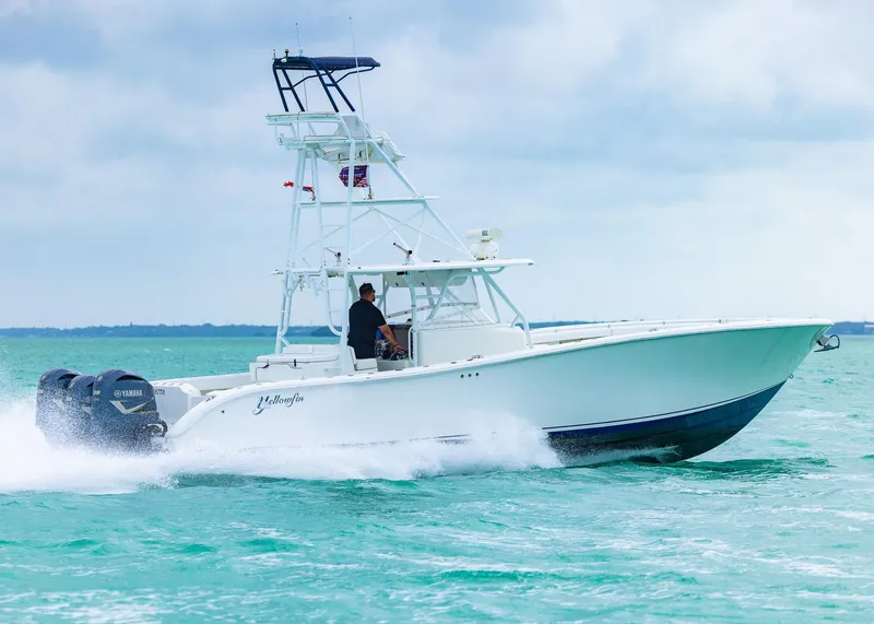 Slide: The Image of 2011 Yellowfin 42 Offshore boat cruising on turquoise water under cloudy sky. - 1