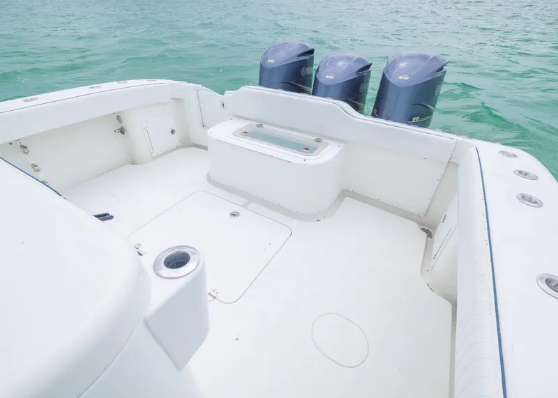 Slide: The Image of 2011 Yellowfin 42 Offshore boat deck with triple outboard motors on turquoise water. - 14