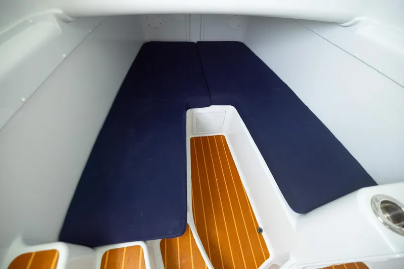 Slide: The Image of 2011 Yellowfin 42 Offshore cabin interior with blue cushions and wooden flooring. - 20