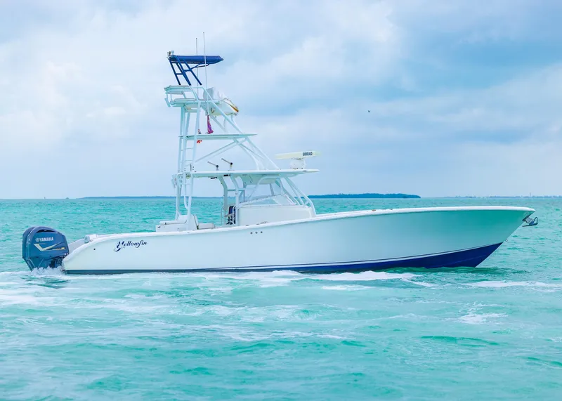 Slide: The Image of 2011 Yellowfin 42 Offshore boat cruising on turquoise waters under a cloudy sky. - 27