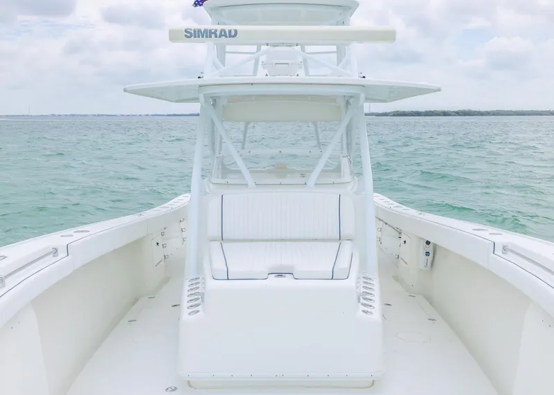 Slide: The Image of 2011 Yellowfin 42 Offshore boat on calm sea, featuring a spacious deck and modern design. - 7