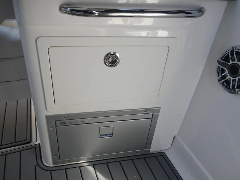 Slide: The Image of 2023 Chaparral 280 OSX boat interior with storage compartment and speaker. - 13