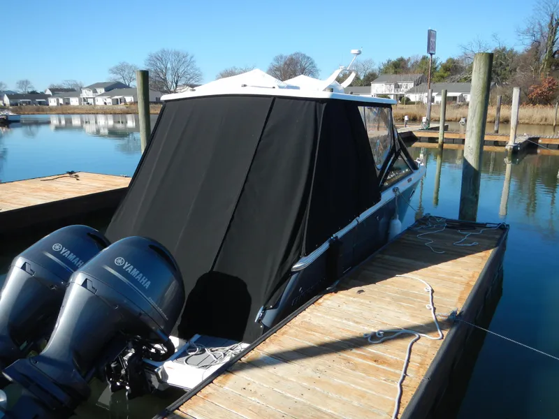 Slide: The Image of 2023 Chaparral 280 OSX boat docked with Yamaha engines, covered in black canvas. - 5