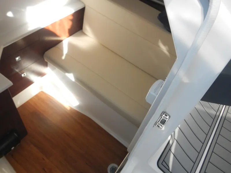 Slide: The Image of 2023 Chaparral 280 OSX interior with beige seating and wooden flooring. - 6