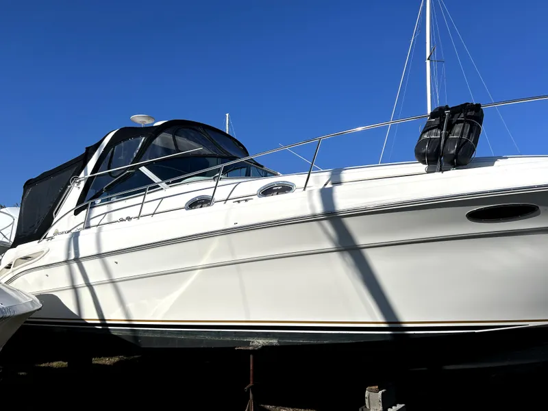 The Image of 2001 Sea Ray 340 Sundancer boat with sleek design, docked under clear blue sky. - 0