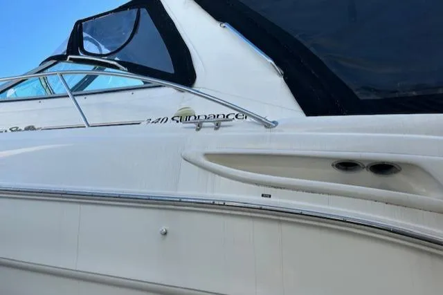 Slide: The Image of 2001 Sea Ray 340 Sundancer boat with sleek design and black canopy. - 2